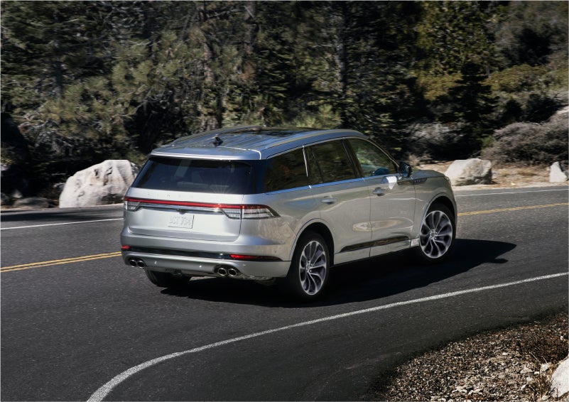 A 2023 Lincoln Aviator® Grand Touring model is shown being driven on a tight turn of a mountain road | Midland Lincoln in Midland MI