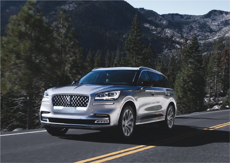 A 2023 Lincoln Aviator® Grand Touring SUV being driven on a winding road to demonstrate the capabilities of all-wheel drive | Midland Lincoln in Midland MI