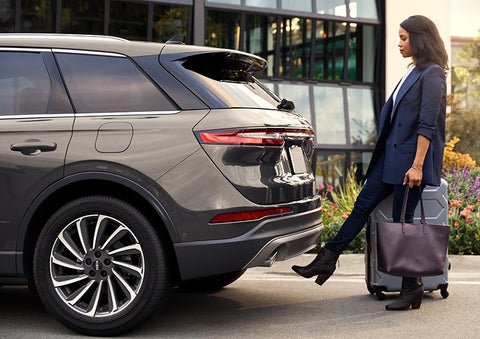 A woman with her hands full uses her foot to activate the hands-free liftgate. | Midland Lincoln in Midland MI