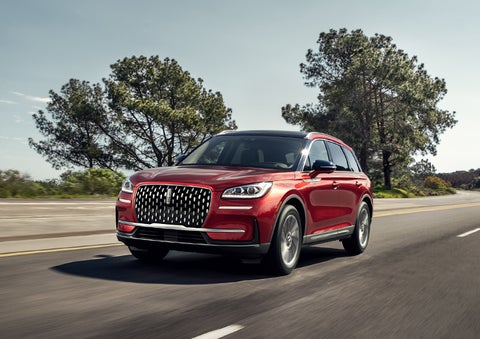 A 2023 Lincoln Corsair® SUV is shown being driven on a country road. | Midland Lincoln in Midland MI