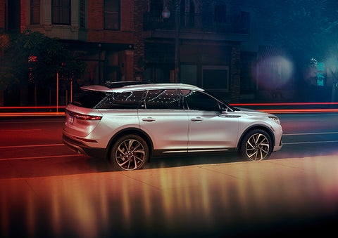 A 2023 Lincoln Corsair® SUV is shown parked in the city at night. | Midland Lincoln in Midland MI