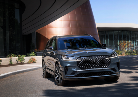 A gray 2025 Lincoln Aviator® SUV is parked outside a modern building with the sun shining. | Midland Lincoln in Midland MI