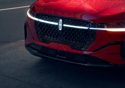 The available front LED light bar and center Lincoln Star logo glow at dusk. | Midland Lincoln in Midland MI