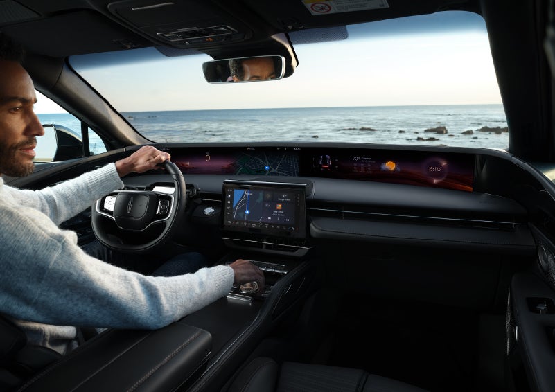 A driver of a parked 2025 Lincoln Nautilus® SUV takes a relaxing moment at a seaside overlook while inside his Nautilus. | Midland Lincoln in Midland MI