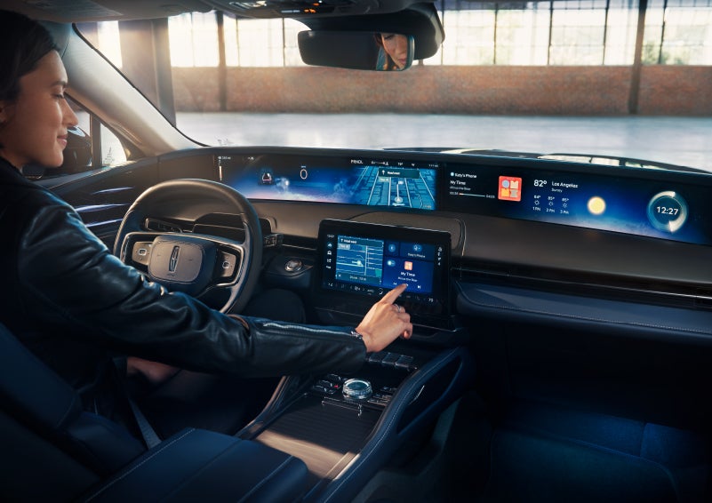 The driver of a 2025 Lincoln Nautilus® SUV interacts with the center touchscreen. | Midland Lincoln in Midland MI