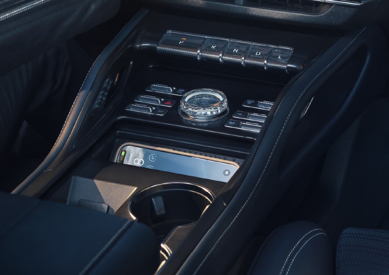 A smartphone is shown charging in the wireless charging pad. | Midland Lincoln in Midland MI