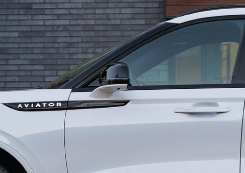 The driver’s side door and fender badging of a white 2026 Lincoln Aviator® SUV are showcased. | Midland Lincoln in Midland MI