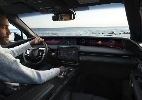 A driver of a parked 2026 Lincoln Nautilus® SUV takes a relaxing moment at a seaside overlook while inside his Nautilus. | Midland Lincoln in Midland MI