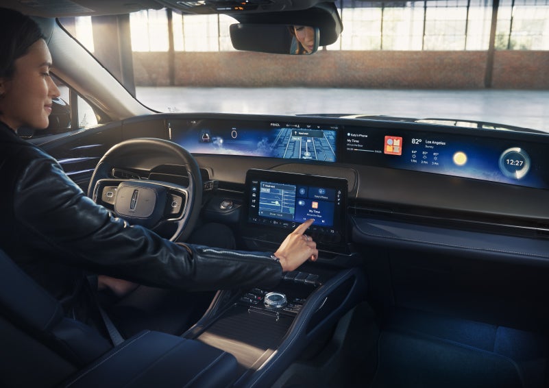 The driver of a 2026 Lincoln Nautilus® SUV interacts with the center touchscreen. | Midland Lincoln in Midland MI