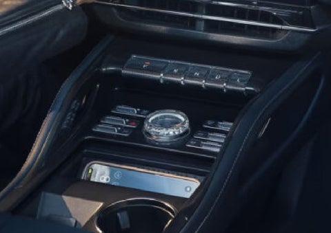 A smartphone is shown charging in the wireless charging pad. | Midland Lincoln in Midland MI