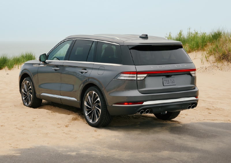 A 2027 Lincoln Aviator® SUV is parked next to sand dunes. | Midland Lincoln in Midland MI