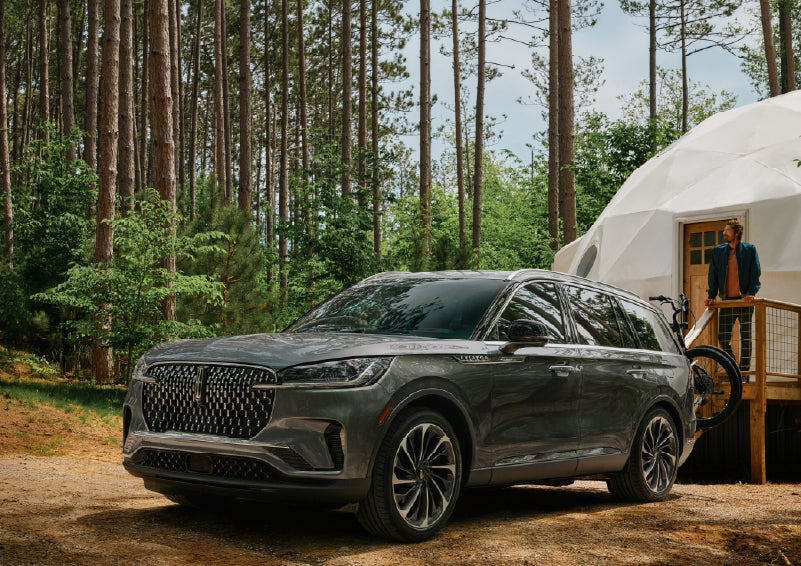 A 2027 Lincoln Aviator® is parked next to a high end glamping site. | Midland Lincoln in Midland MI