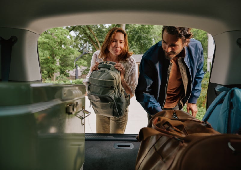 A couple loads luggage into the rear of a 2027 Lincoln Aviator® Black Label™ SUV..e 202 | Midland Lincoln in Midland MI
