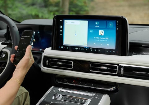A person pairs thier phone with the center touchscreen of a 2027 Lincoln Aviator® Black Label™ SUV | Midland Lincoln in Midland MI